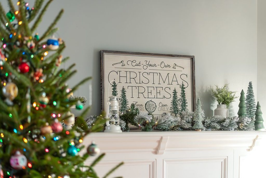 Flocked garland and miniature trees on white mantel